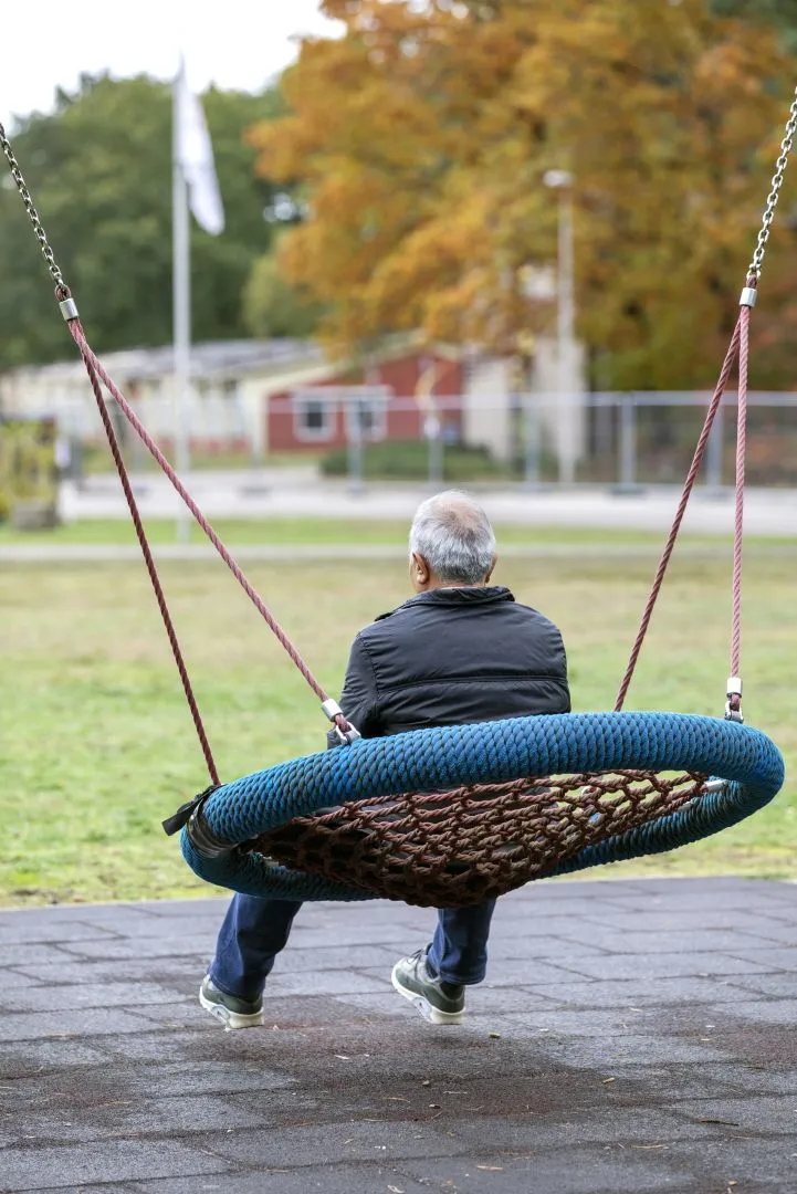 Man op schommel bij opvangplek