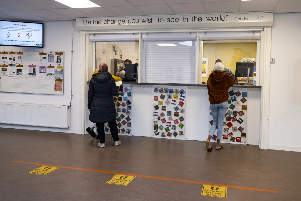 Vluchtelingen staan aan de balie met vragen over gezinshereniging