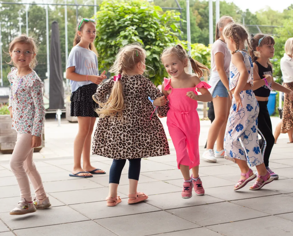 Kinderen dansen op het kindervakantiefestival van VluchtelingenWerk
