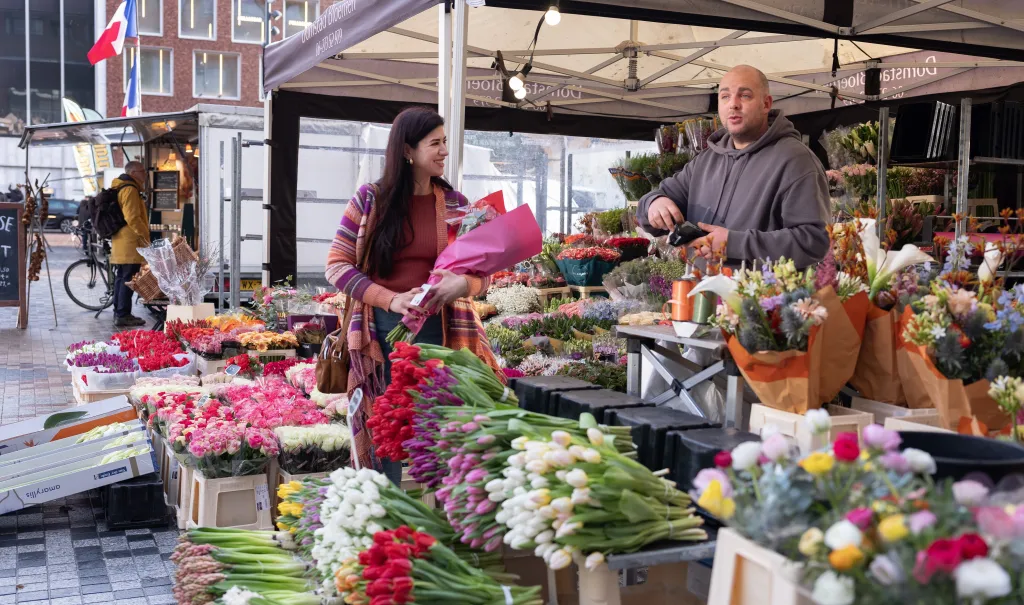 Yara, gevlucht uit Syrië, koopt bloemen op de markt in Bunnik. 
