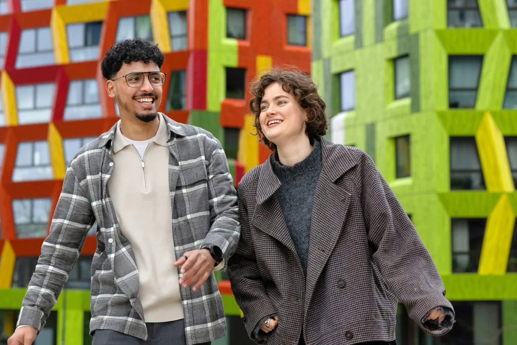 Moha en Lotta, vrienden dankzij het project wake up your mind, lopen glimlachend naast elkaar. 