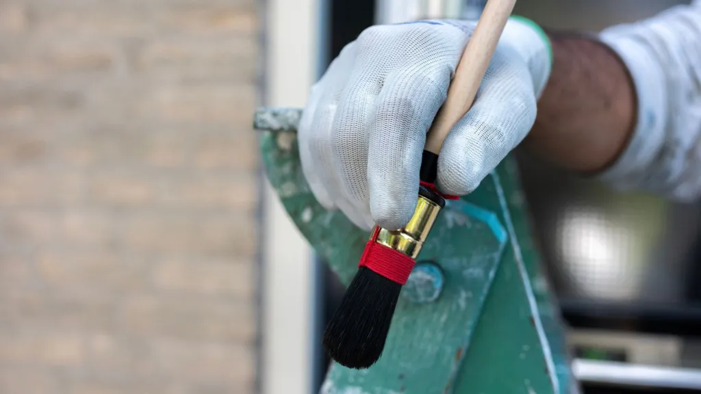 Een hand houdt een schilderskwast vast